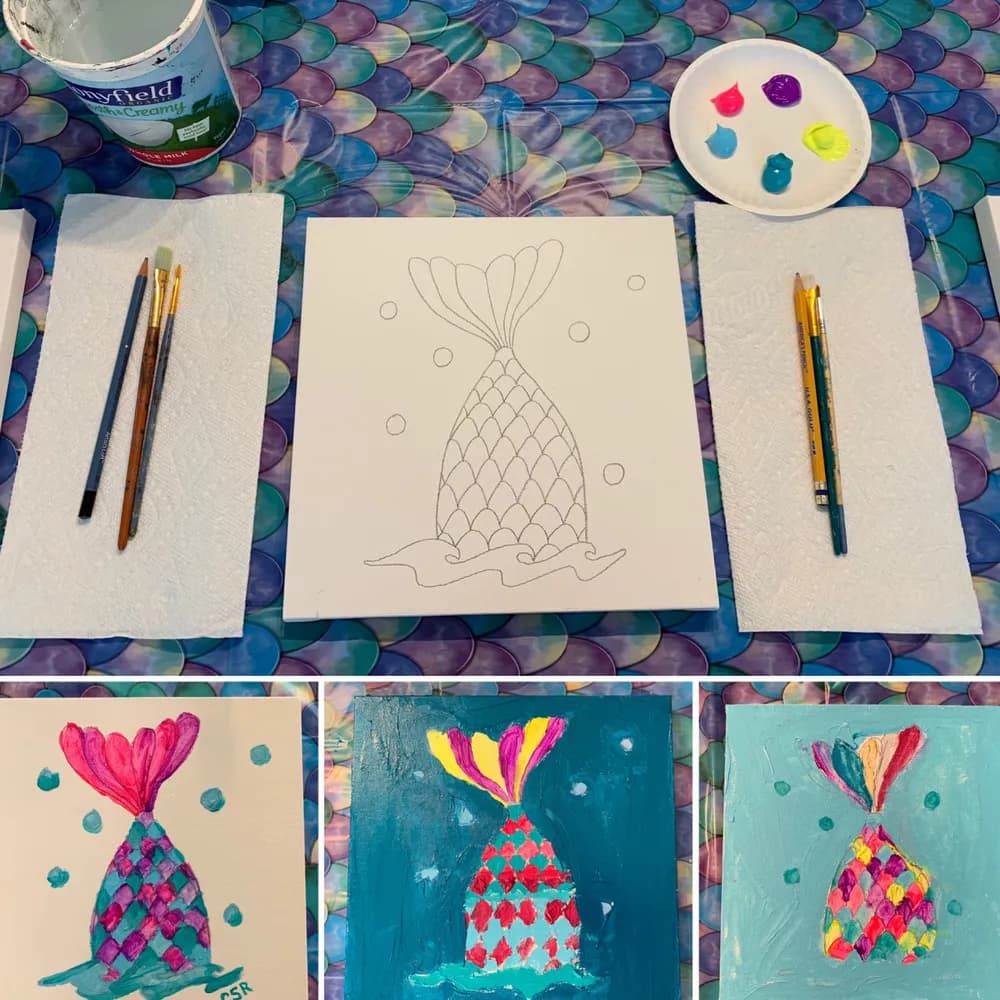 Pre-sketched mermaid tail canvas with brushes, a paint palette, and three finished mermaid paintings from a kids painting party in McKinney, TX