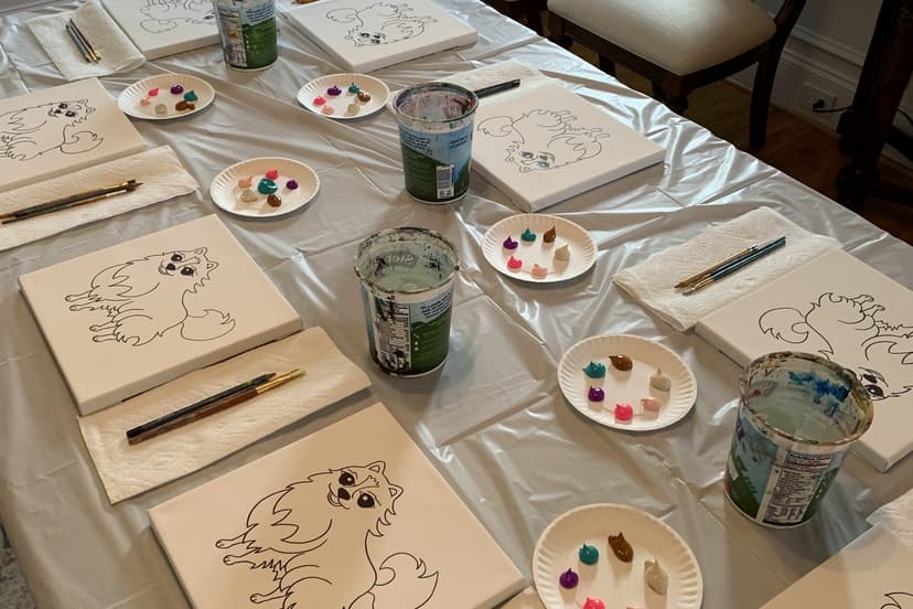 Paint party table set with pre-sketched puppy canvases, palettes, and brushes